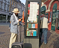 Mann betrachtet Buch vor Bücherschrank