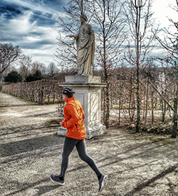 Jogger im Park passiert Statue
