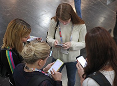 Vier Frauen blicken auf Smartphones